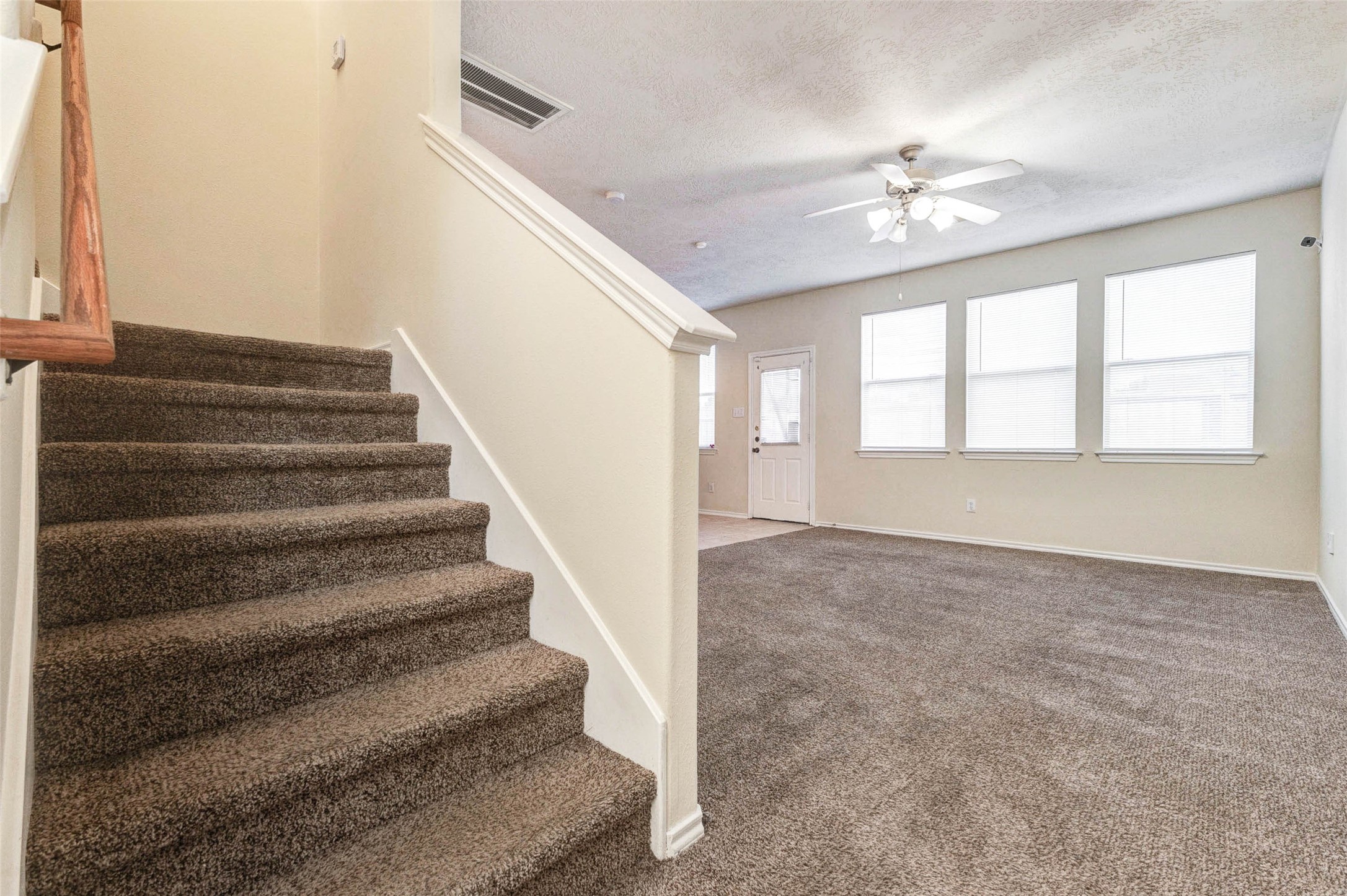 13106 Peppergate Lane Houston, TX 77044 - Photo 7 of 17 a view of an empty room with staircase and white walls