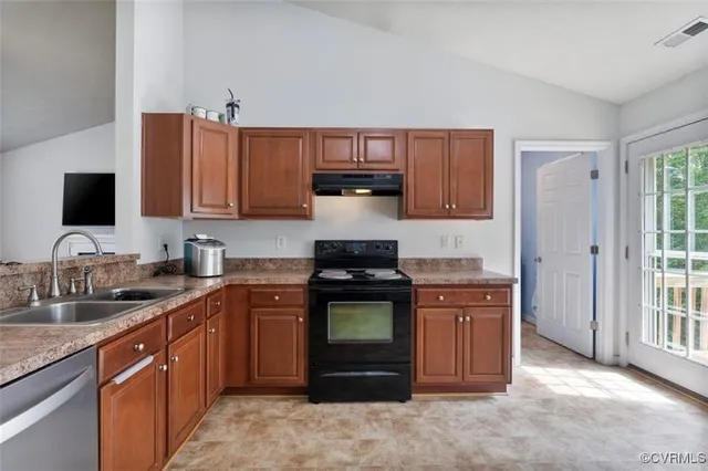 a kitchen with stainless steel appliances granite countertop a stove top oven a sink dishwasher and a microwave oven on the blue kitchen countertops