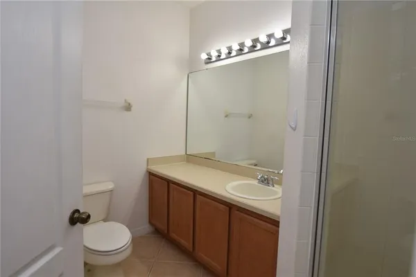 a bathroom with a granite countertop sink a toilet and a mirror