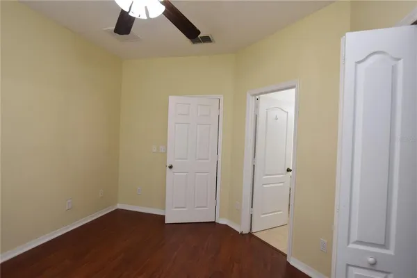an empty room with closet and a chandelier fan