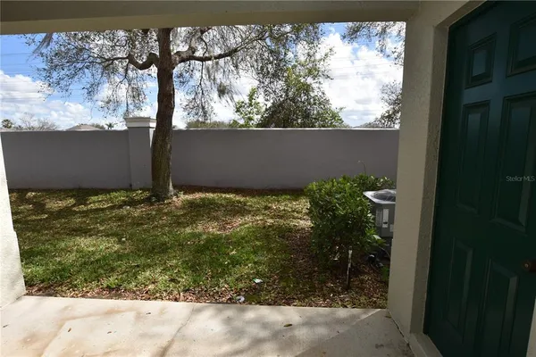 a view of a door and chair in back yard of a house