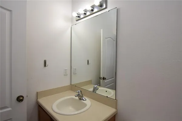 a bathroom with a sink mirror and vanity