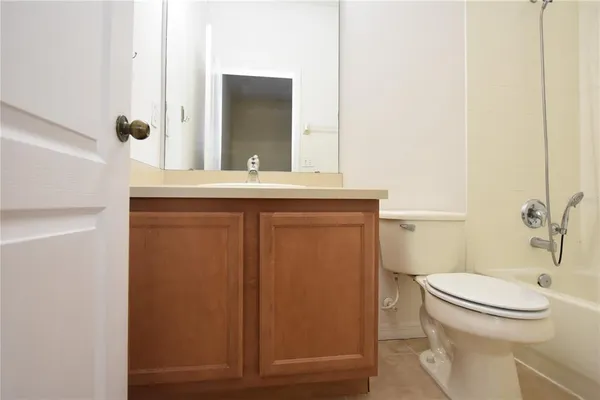 a bathroom with a granite countertop toilet sink and mirror