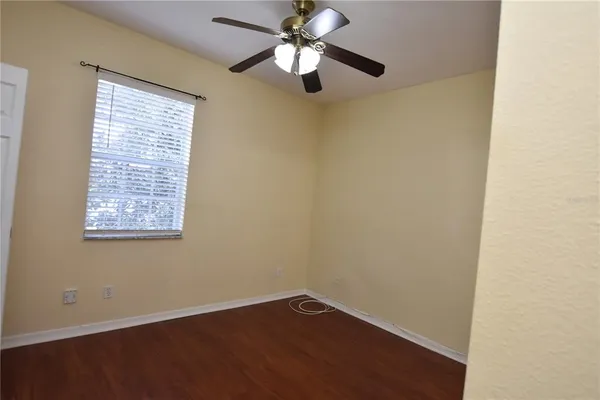an empty room with a window and a fan