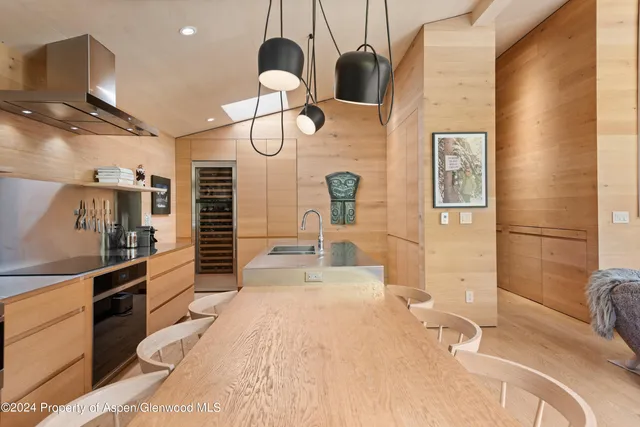 a large kitchen with kitchen island a large counter space a sink stainless steel appliances and cabinets