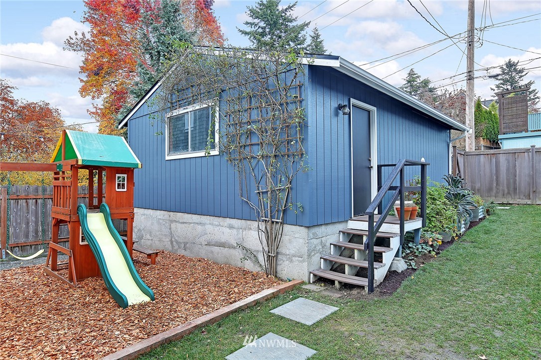 1936 47th Avenue Southwest Seattle, WA 98116 - Photo 24 of 25 a view of a backyard with a slide and wooden fence