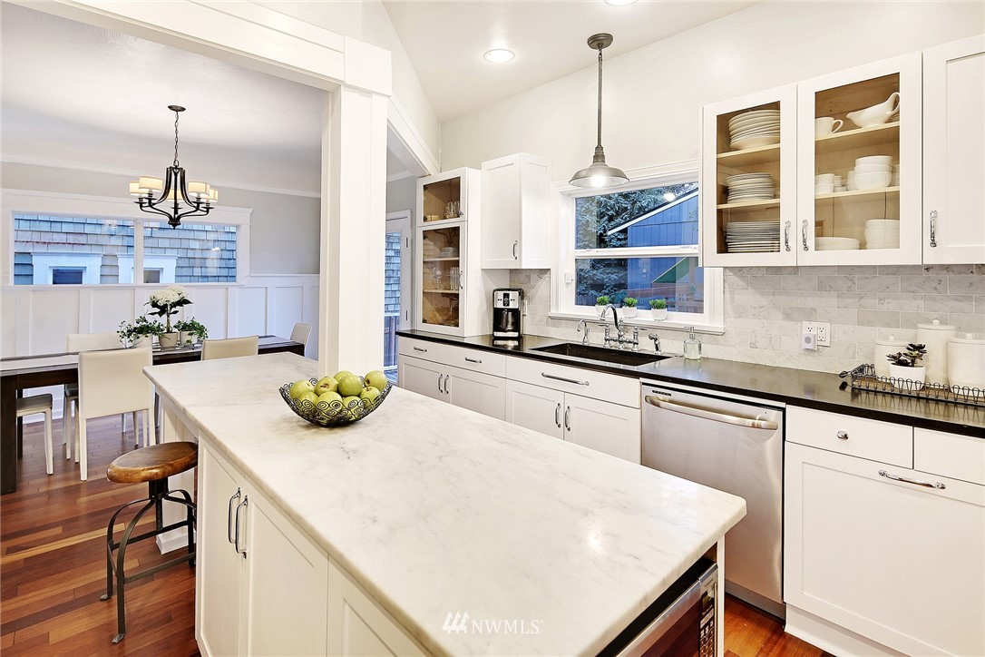 1936 47th Avenue Southwest Seattle, WA 98116 - Photo 9 of 25 a kitchen with a sink a stove and chairs