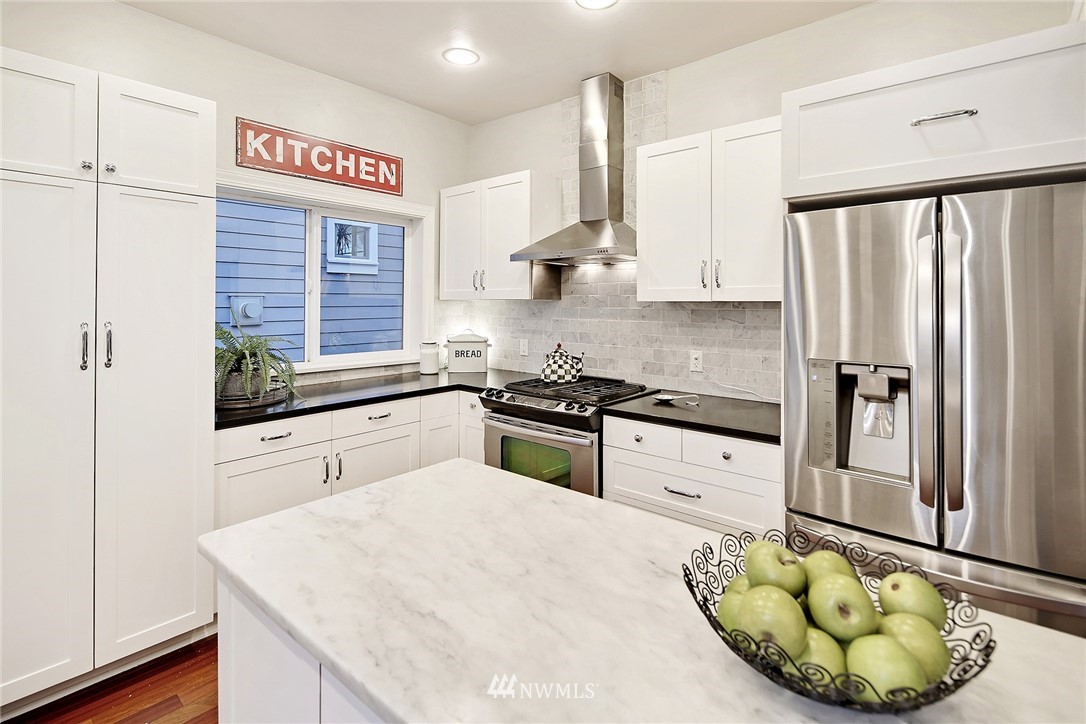 1936 47th Avenue Southwest Seattle, WA 98116 - Photo 10 of 25 a kitchen with stainless steel appliances a refrigerator sink and cabinets