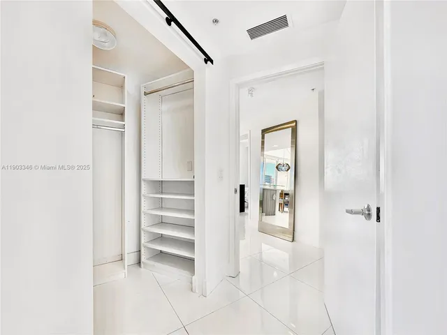 a view of a hallway with closet and bathroom