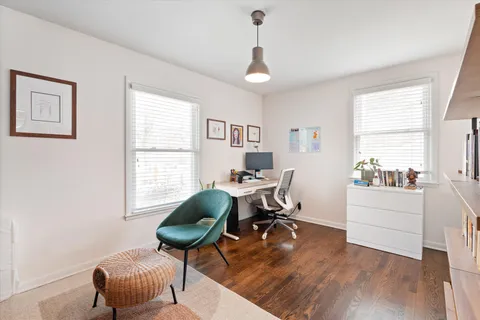a view of a workspace with furniture and a window
