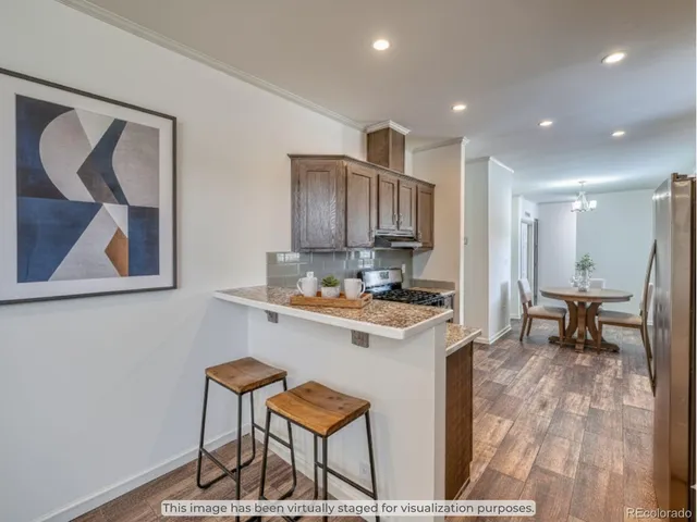 a kitchen with a sink a refrigerator and chairs