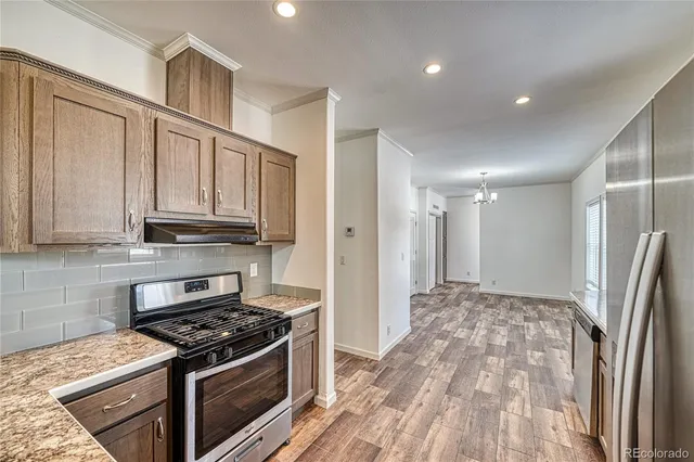 a kitchen with stainless steel appliances granite countertop a stove a refrigerator and a microwave