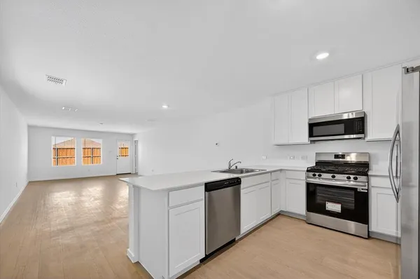 a kitchen with stainless steel appliances a stove sink and cabinets