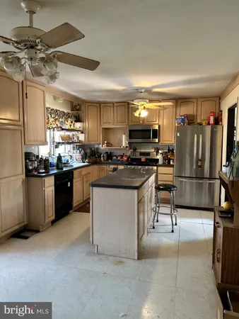 a kitchen with stainless steel appliances a refrigerator a stove a sink a dining table and chairs