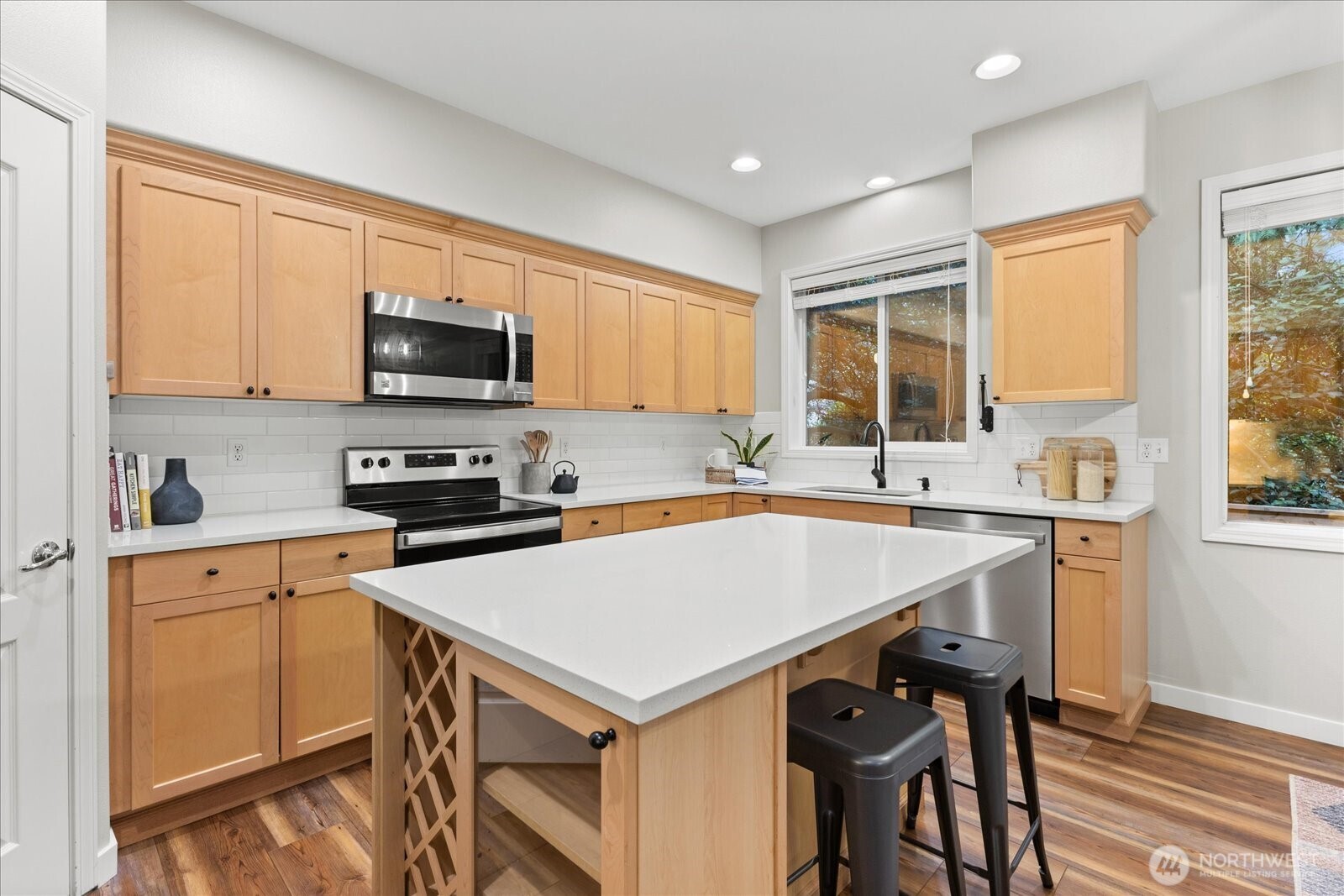 16526 Southeast 256th Street, Unit C3 Covington, WA 98042 - Photo 8 of 26 a kitchen with a stove a sink a microwave a dining table and chairs