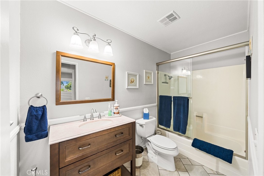 4040 Penrod Drive Riverside, CA 92505 - Photo 12 of 30 a bathroom with a toilet a sink a mirror a shower and vanity