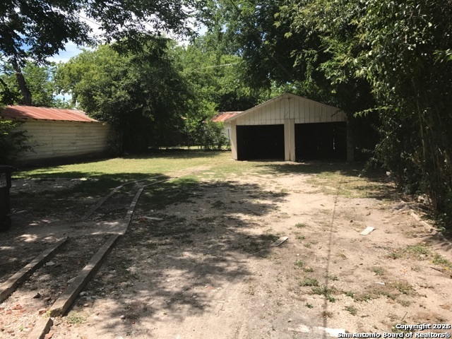 215 Rigsby Avenue San Antonio, TX 78210 - Photo 13 of 13 a backyard of a house with large trees and a wooden fence