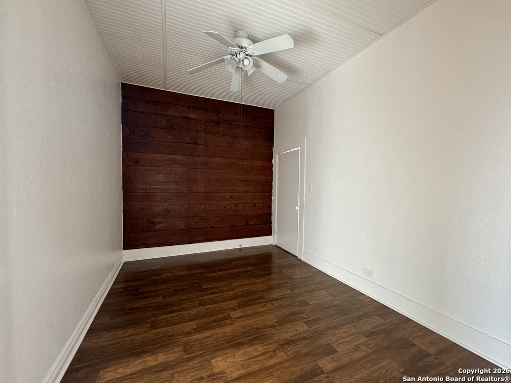 215 Rigsby Avenue San Antonio, TX 78210 - Photo 3 of 13 an empty room with wooden floor fan and windows