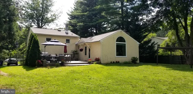 a front view of house with yard and trees in the background