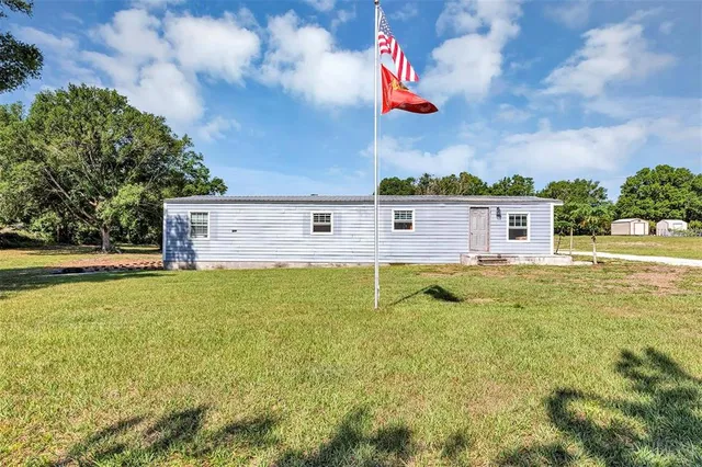 an aerial view of a house with a yard and large trees