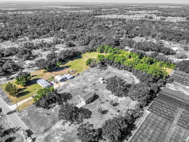 an aerial view of residential house with swimming pool and lawn chairs