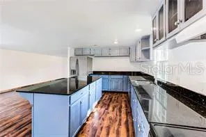 a kitchen with granite countertop a sink and a stove top oven