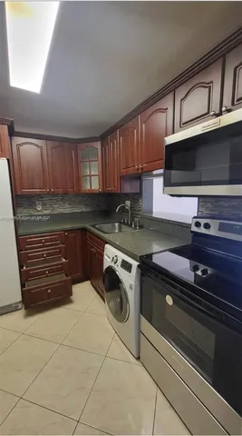 a kitchen with granite countertop cabinets stainless steel appliances and a sink