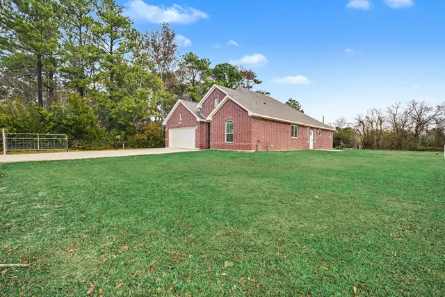 a front view of a house with a yard and trees