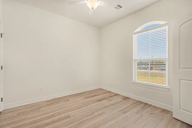 wooden floor in an empty room with a window
