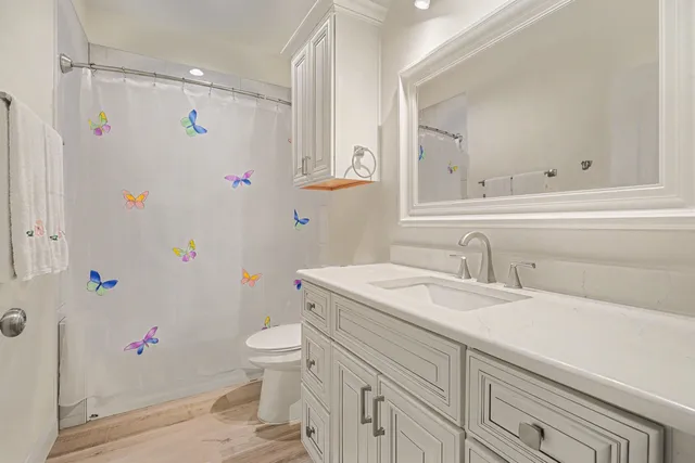 a bathroom with a sink a toilet and a mirror