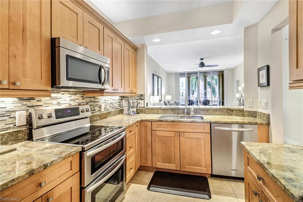 401 Bayfront Place, Unit 3205 Naples, FL 34102 - Photo 5 of 35 a kitchen with stainless steel appliances granite countertop a stove microwave and cabinets
