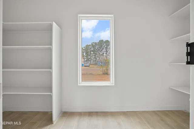 a view of a small space with wooden floor and a window