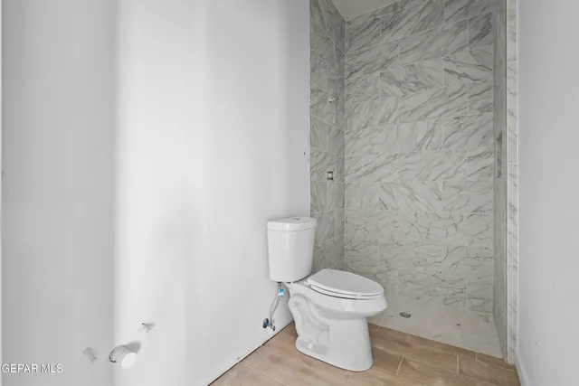 a white toilet sitting next to a white wall