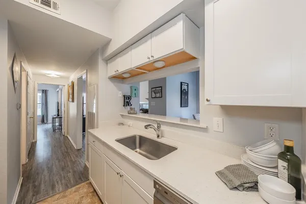 a kitchen with a sink cabinets and wooden floor