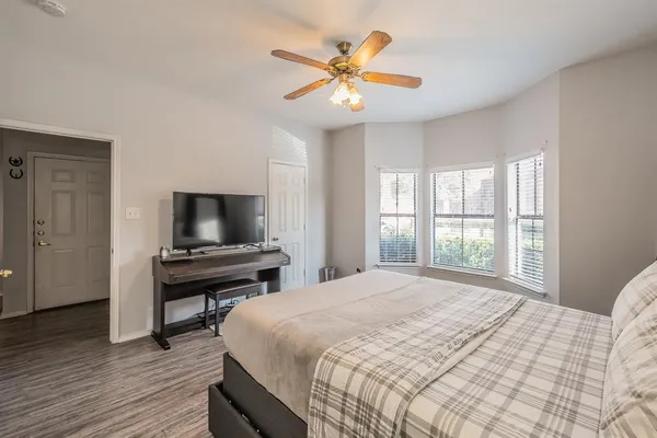 a bedroom with a bed and a flat screen tv with wooden floor