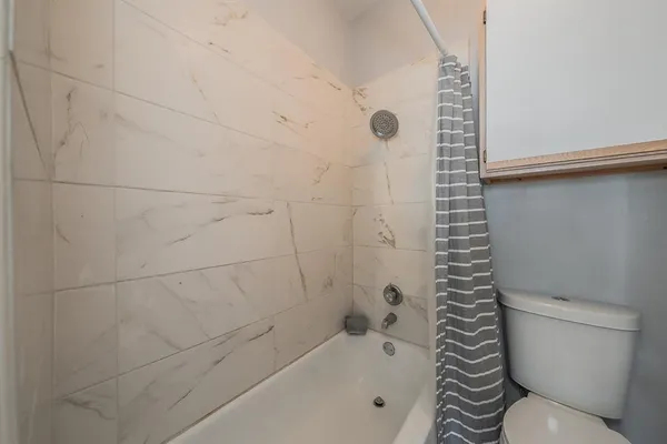 a bathroom with a toilet and a shower