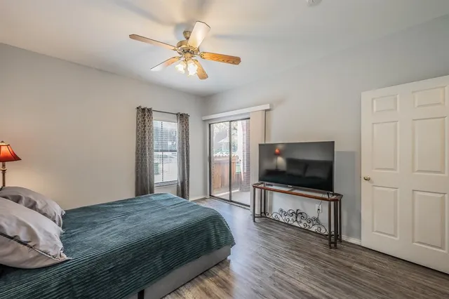 a bedroom with a large bed a flat tv screen and a chandelier