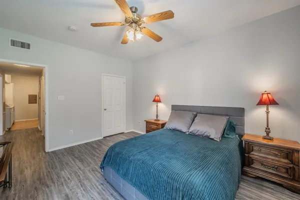 a bedroom with a bed and wooden floor