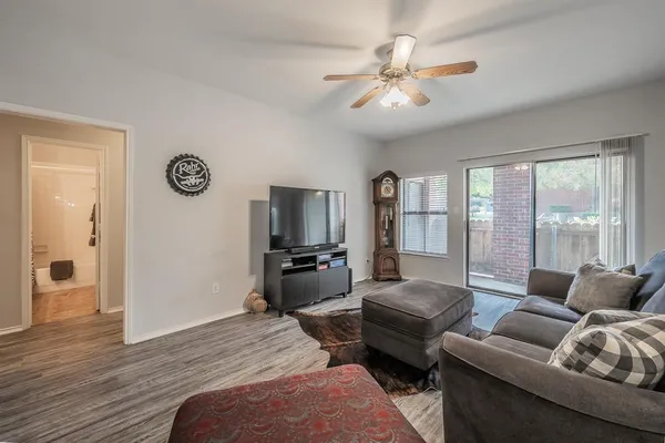 a living room with furniture a large window and a flat screen tv