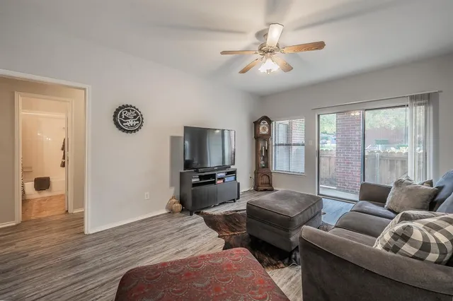 a living room with furniture a large window and a flat screen tv