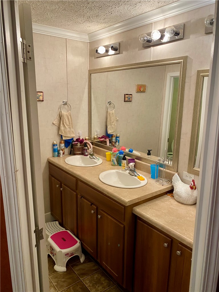 597 Sam Byrum Road Iva, SC 29655 - Photo 25 of 43 This bathroom features dual sinks and warm wood cabinetry, providing both comfort and utility.