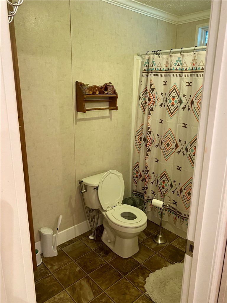 597 Sam Byrum Road Iva, SC 29655 - Photo 26 of 43 This bathroom features durable tile flooring, crown molding, and a convenient shower.