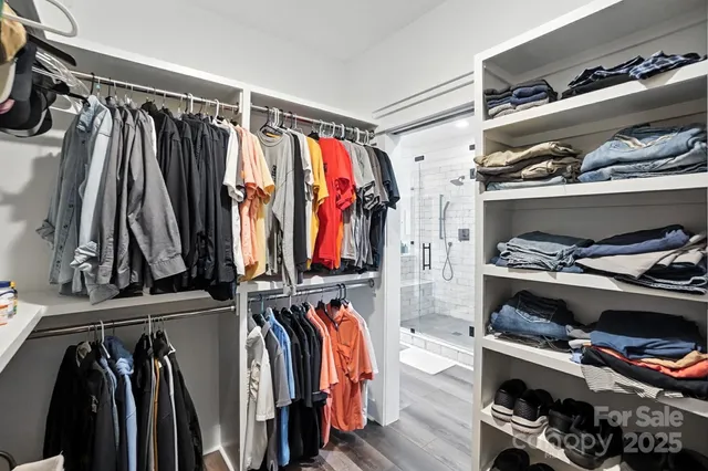 a view of walk in closet with clothes and shoes