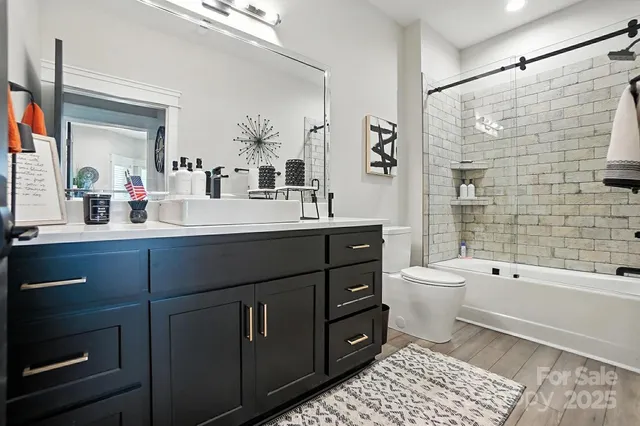 a bathroom with a sink a toilet and shower