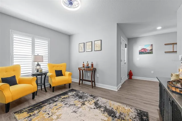 a living room with stainless steel appliances furniture cabinets and a wooden floor