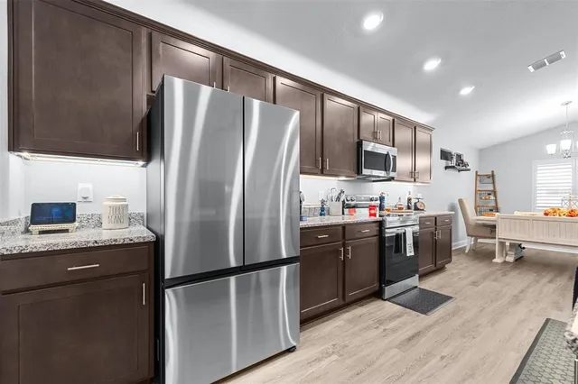 a kitchen with stainless steel appliances granite countertop a sink stove and refrigerator