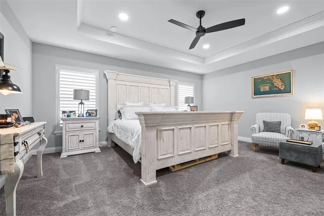 a bedroom with a bed a couch and a flat screen tv