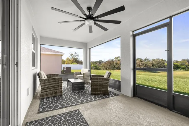 a view of a field with an ocean and trees in the background