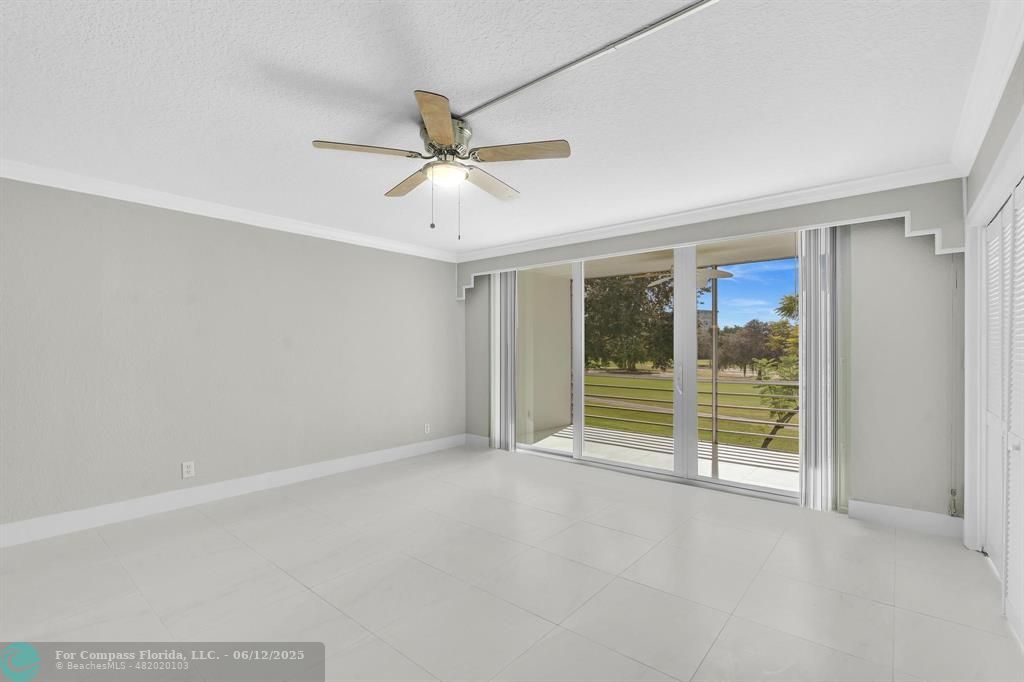 3800 Oaks Clubhouse Drive, Unit 201 Pompano Beach, FL 33069 - Photo 17 of 29 an empty room with sliding glass door