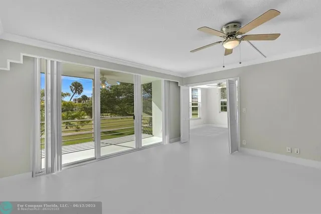 an empty room with fan and windows